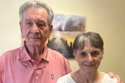 Two women enjoying a lively conversation indoors, showcasing stylish and colorful attire.